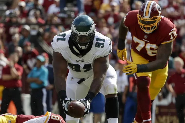 Eagles defensive tackle Fletcher Cox recovers a fumble against Redskins quarterback Kirk Cousins and past offensive tackle Morgan Moses in the Eagles’ 30-17 win on Sunday.