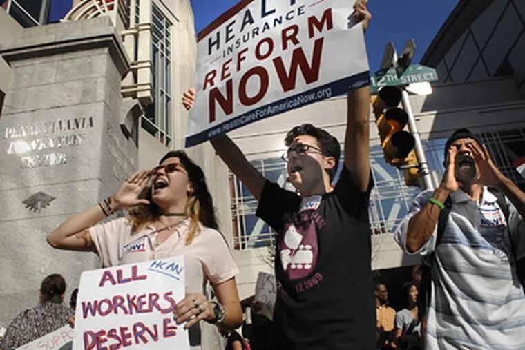 Kelsey Grondahl (left), 18, a freshman at the University of the Arts; Paul Zilberman, 18, also a freshman at the University of the Arts; and Andre Cureton of North Philadelphia advocate for health care reform in front of the Pennsylvania Convention Center yesterday.  (Alyssa Cwanger / Staff Photographer)