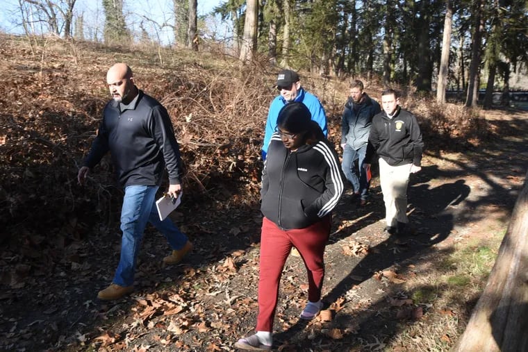 Noema Alavez Perez walks with investigators last week on a wooded trail near the playground in Bridgeton City Park in the continuing search for clues for her missing 5-year-old daughter, Dulce Maria Alavez.