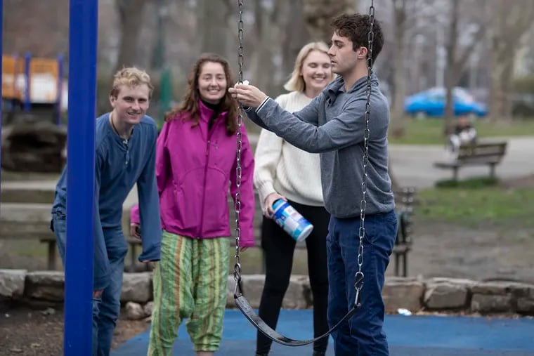 People were making use of Clark Park in West Philadelphia to escape the concerns of the virus and to get some exercise and fresh air on March 19, 2020. Jack Flahive, right, uses disinfecting wipes  before his group of Penn students used the swings. L-R: Mason Mings, Sophie Thorel, kim Amelsberg, and Jack Flahive.