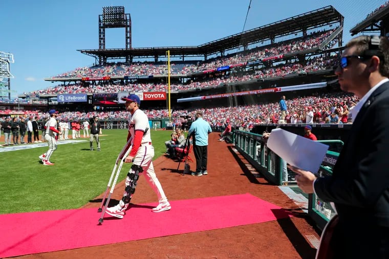 Rhys Hoskins takes the field on crutches to receive his ring during the Phillies game against the Reds at Citizens Bank Park on Sunday.