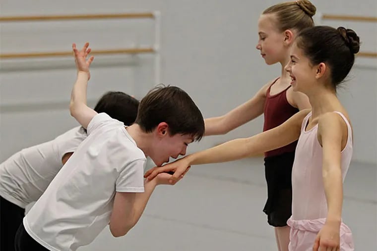Jane Cohen, 10, center, breaks into nervous giggles after Aidan Duffy, 9, kissed her hand during rehearsals of&quot;George Balanchine's The Nutcracker&quot; at the School of Pennsylvania Ballet. (Michael Bryant/Staff Photographer)