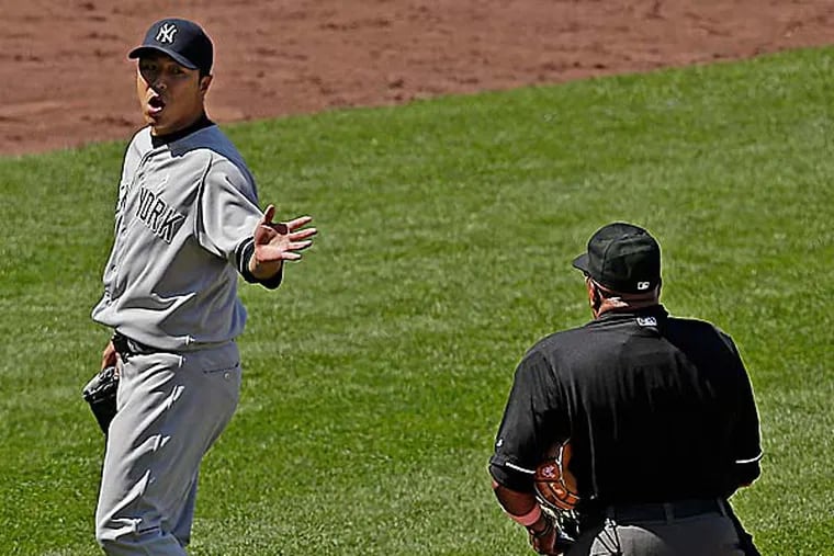New York Yankees starting pitcher Hiroki Kuroda talks to an official after coming out ot the game during the eighth inning. (Charlie Riedel/AP)