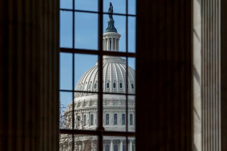 The Capitol is framed through a window in the Russell Senate Office Building as lawmakers negotiate on the emergency coronavirus response legislation, at the Capitol in Washington, Wednesday, March 18, 2020. (AP Photo/J. Scott Applewhite)