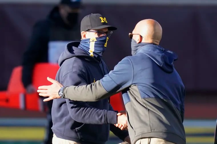 James Franklin (right) shakes hands with Michigan coach Jim Harbaugh after Saturday's game.