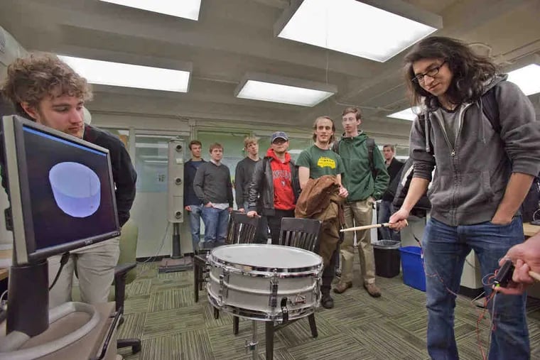 Jedtsada Laucharoen, a mechanical-engineering student, plays a virtual drum on the Penn campus. When a wooden drumstickis wielded in midair, a tap is felt (and heard) even though no drum has actually been struck.