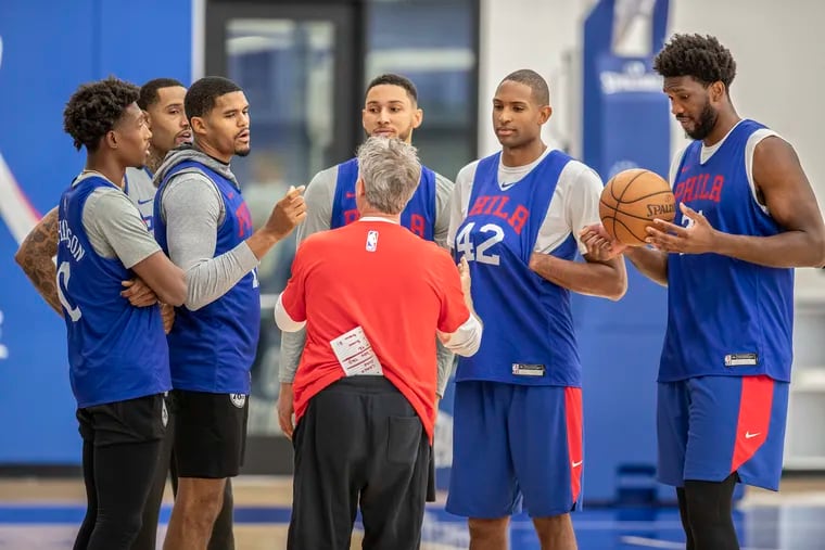 Sixers head coach Brett Brown, back to camera, holds a meeting on the court after practice with , left to right, Josh Richardson, Mike Scott, Tobias Harris, Ben Simmons , Al Horford, and Joel Embiid, at the Sixers practice facility in Camden NJ on October 16, 2019.