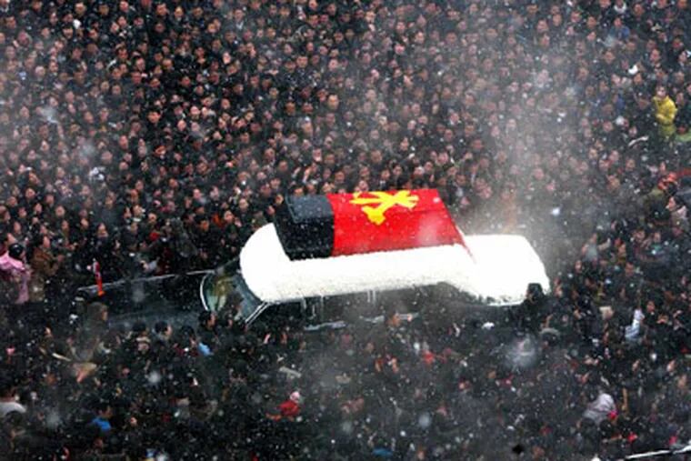 In this Wednesday, Dec. 28, 2011 photo released by the Korean Central News Agency and distributed in Tokyo, Dec. 29, 2011 by the Korea News Service, mourners surround the hearse carrying the coffin of the late North Korean leader Kim Jong Il during his funeral procession through the streets of Pyongyang, North Korea.  (AP Photo/Korean Central News Agency via Korea News Service) JAPAN OUT UNTIL 14 DAYS AFTER THE DAY OF TRANSMISSION