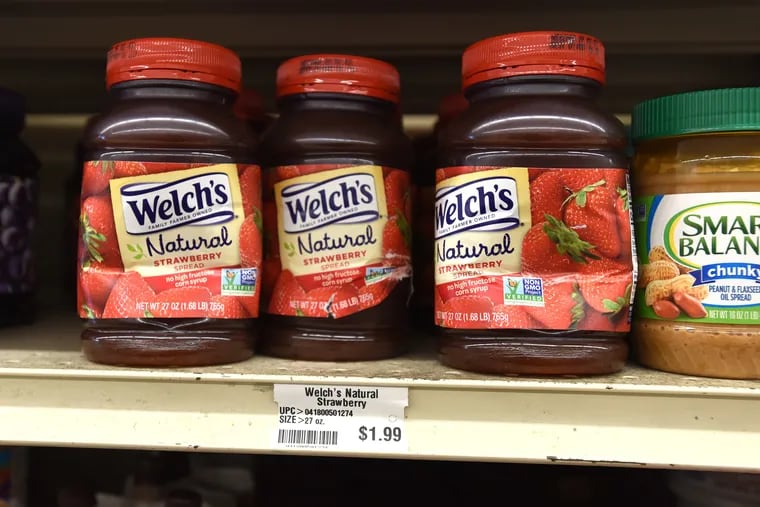 Banged-up plastic jars of Welch's strawberry spread sit on a shelf at Green Hills Farm Discount Grocer, a so-called dent-and-bent store in Lititz, Lancaster County. Normally more than $4, each jar goes for $1.99.