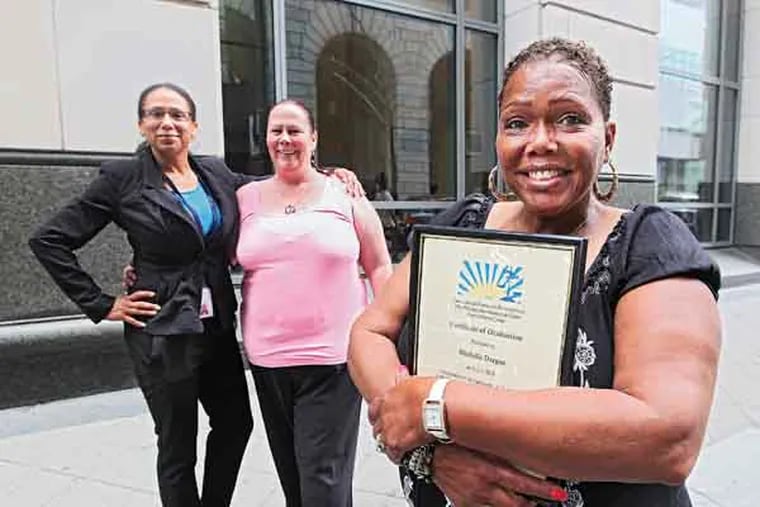 Michelle Dargan, right, a graduated from the Project Dawn program on Tuesday and is very happy and proud of what she has accomplished. Lesha Sanders, left, Coordinator of the program, and Ann-Marie Jones, also a past graduate, were there for the ceremonies and support. Project Dawn Court, an innovative system of dealing with repeat prostitution offenders, celebrates it's first anniversary with a graduation Tuesday.  07/09/2013 ( MICHAEL BRYANT / Staff Photographer )