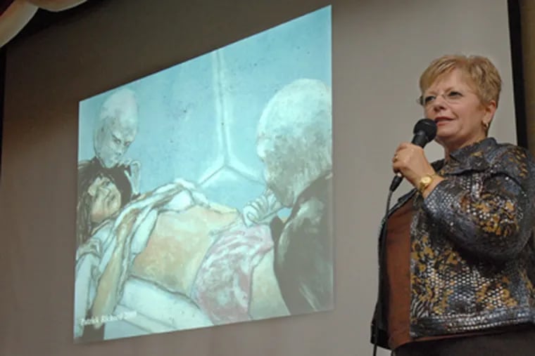Kathleen Mardens speaks about the experiences of her aunt and uncle, Betty and Barney Hill, who claimed that they were abducted by aliens in 1961. The slide is an artist's rendering of Betty Hill being examined by aliens. (April Saul / Staff Photographer)