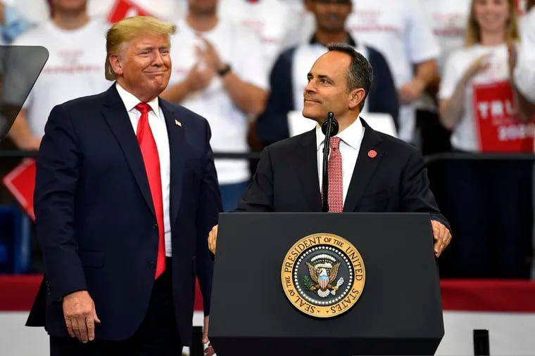 Kentucky Gov. Matt Bevin, right, looks out at the crowd as President Donald Trump watches during a campaign rally in Lexington, Ky., Monday, Nov. 4, 2019.