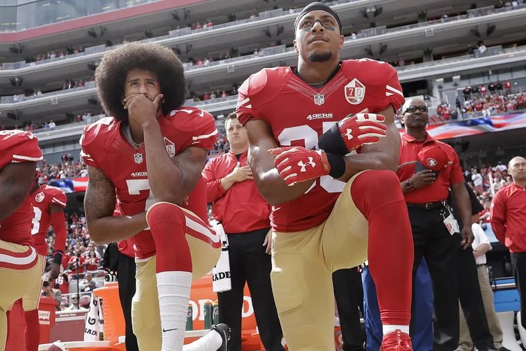 San Francisco safety Eric Reid (right) kneels next to former 49ers quarterback Colin Kaepernick during the national anthem before a game last season. (AP Photo/Marcio Jose Sanchez)