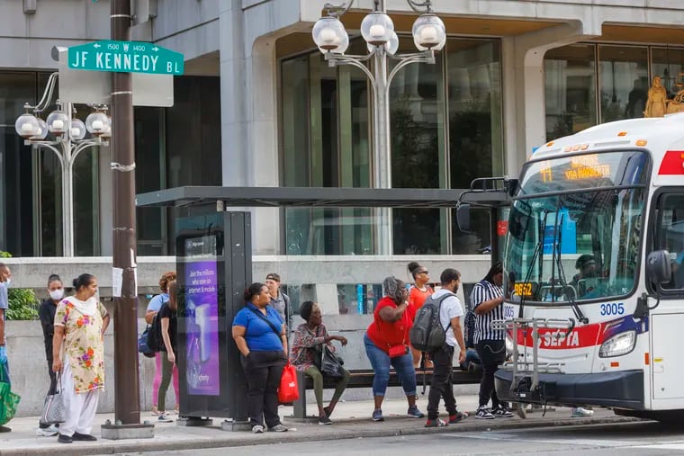 Commuters waiting at bus stop along JFK Blvd at 15th Street in front of the Municipal Services Building in Center City Philadelphia on Monday, August 14, 2023.