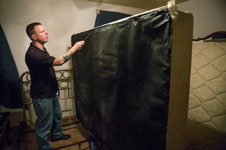 Jeremy Evans, Service Manager for Evans Pest Control, inspects a mattress for bedbugs, in Northeast Philadelphia, Wednesday, June 27, 2018. JESSICA GRIFFIN / Staff Photographer.