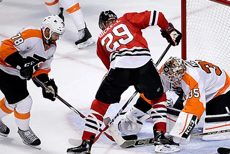 Flyers right wing Pierre-Edouard Bellemare and goalie Steve Mason keep Blackhawks left wing Bryan Bickell from getting a shot on goal during the second period. (Charles Rex Arbogast/AP)