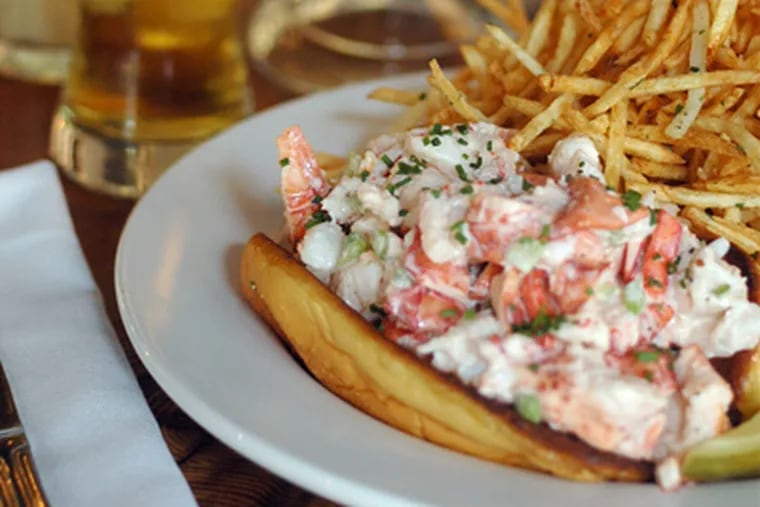 A New England lobster roll (left) served with shoestring fries and a glass of beer.