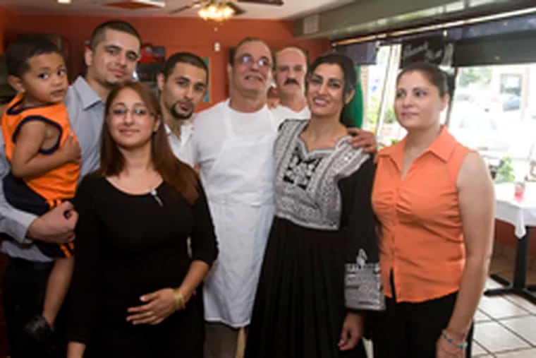 The Rahpo family at their Yalda Grill - (from left) Niez (holding nephew Zemar), Laila, Omid (in apron), Moe, Nehide, and Nehide&#0039;s sister Fareema. Pizza maker Basir Bazli is at rear.