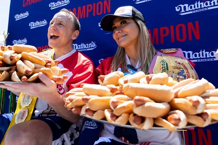 Joey Chestnut and Miki Sudo pose with 63 and 40 hot dogs, respectively, after winning the Nathan's Famous Fourth of July hot dog eating contest in Coney Island on Monday, July 4, 2022, in New York. (AP Photo/Julia Nikhinson)