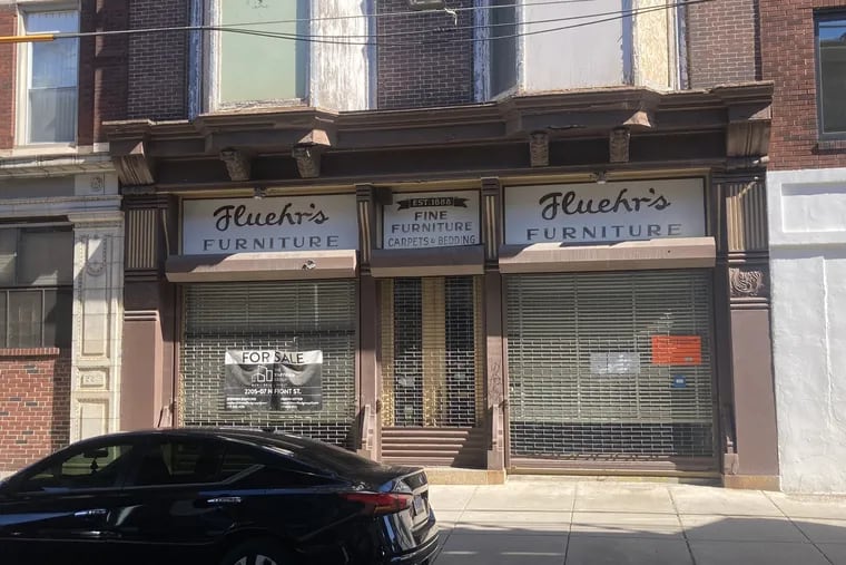 The front facade of Fluehr's Furniture Store, under the Market-Frankford line, in Kensington.
