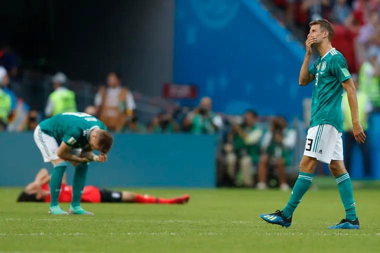 Germany's Thomas Mueller, right, wipes his face after his team lose the group F match between South Korea and Germany, at the 2018 soccer World Cup in the Kazan Arena in Kazan, Russia, Wednesday, June 27, 2018. South Korea won the match 2-0.