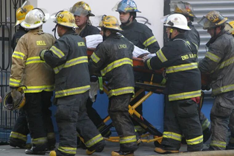 The bodies of two Philadelphia firefighters are brought out of a collapsed building after a five-alarm fire in Kensington on Monday morning April 9, 2012. (ALEJANDRO A. ALVAREZ / STAFF PHOTOGRAPHER)