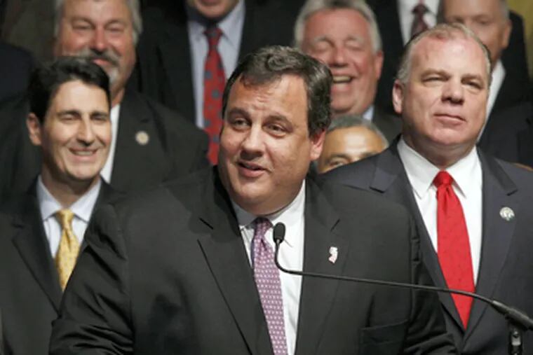 A pleased Gov. Christie answers a question after signing legislation raising payments for health and pension benefits. At right is Sen. Stephen Sweeney. (Mel Evans / AP Photo)