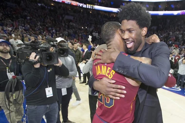 LeBron James (left) hugs Joel Embiid after an April 2018 game at the Wells Fargo Center. With James off to the Western Conference, Embiid could be come the face of the East.