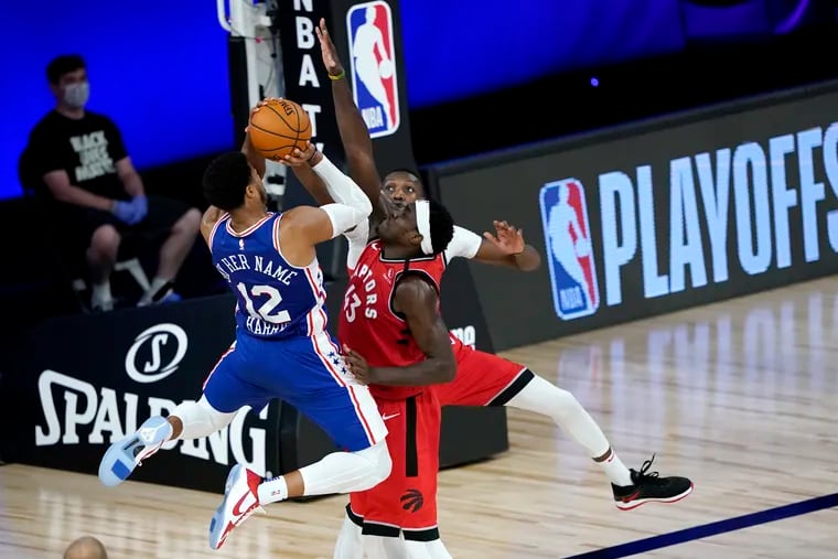 Philadelphia 76ers' Tobias Harris (12) goes up for a shot against Toronto Raptors' Pascal Siakam, center, and Chris Boucher during the first half of an NBA basketball game Wednesday, Aug. 12, 2020 in Lake Buena Vista, Fla. (AP Photo/Ashley Landis, Pool)