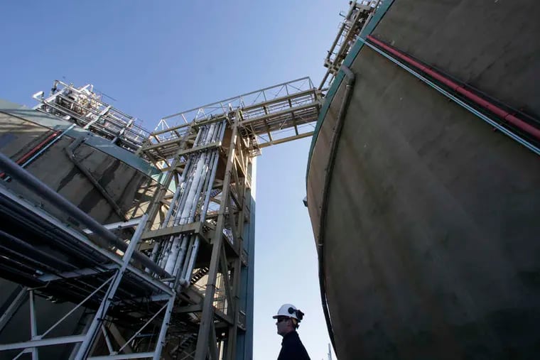At Philadelphia Gas Works Richmond plant, program manager James Kluzinski stands between two huge storage tanks of liquid natural gas.