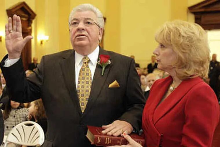 Mario Civera, state rep. who promised to step down if elected to Delco council, and has not, is sworn in yesterday, as wife, Donna, looks on.