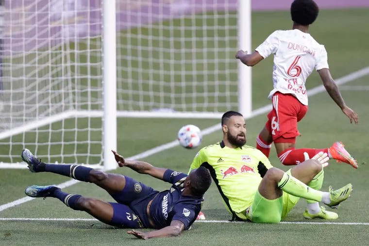 Cory Burke watches his first-half shot go past New York Red Bulls goalkeeper Carlos Miguel Coronel and roll into the net for a goal.
