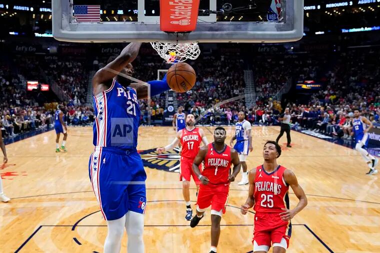76ers center Joel Embiid (21) slam dunks in the first half against the New Orleans Pelicans on Friday.