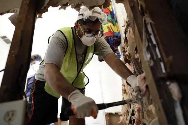 Volunteer Hashir Ayubi, of the the Ahmadiyya Muslim Youth Association helps clean out a flood-damaged home in Houston on Sunday, Sept. 3, 2017.