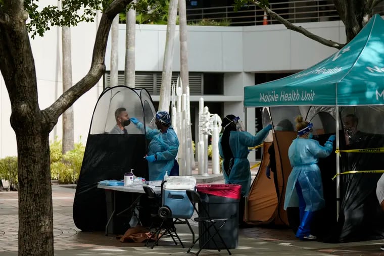 People are tested for COVID-19 at a walk-up testing site in downtown Miami.