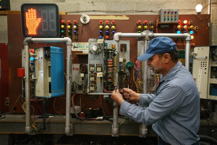 Ibrahim El-Hajmoussa, an electronic technician, demonstrates the mechanical synchronizer on the older traffic lights, at the traffic control center, in Philadelphia. Almost 2,000 of the city's traffic lights are too old to link into the central control system and have to be calibrated by hand, which is a time-consuming process and creates problems with managing traffic.