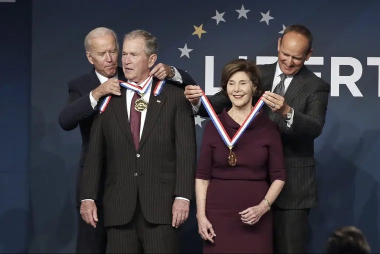 Former Vice President Joe Biden (left) and National Constitution Center Committee Chairman Doug DeVos (right) present former President George W. Bush and First Lady Laura Bush with the 2018 Liberty Medal during ceremonies at the National Constitution Center in Philadelphia on Sunday.