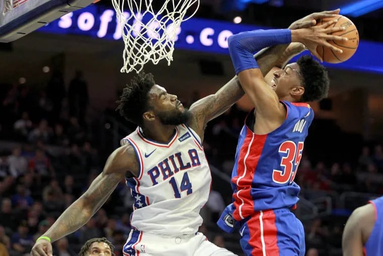 Norvel Pelle, left, of the Sixers blocks a shot by Christian Wood of the Pistons during the 4th quarter of their NBA preseason game at the Wells Fargo Center on Oct.15, 2019.