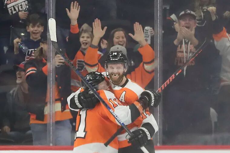 Flyers center Sean Couturier celebrates his game-winning overtime goal with teammate center Travis Konecny.