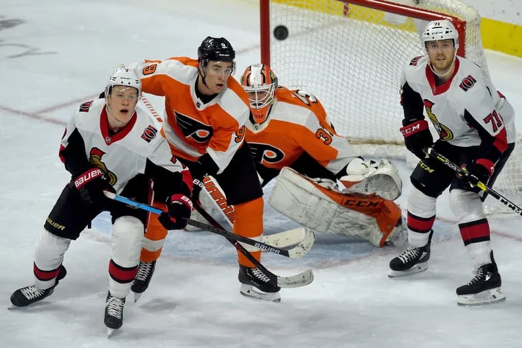 From left, Ottawa's Brady Tkachuk, the Flyers' Ivan Provorov, goaltender Brian Elliott and Ottawa's Chris Tierney eye an airborne puck during the third period.