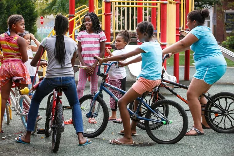 Nasirah Foreman, 9, Jaszlynn Lopez, 7, Chloe Moye, 11, Jayla Moye Bellinger, 9, Kaitlyn Moye, 6, Georgette Floyd, 12, and Diyanna Hall, 10, (Far Left to Right) hang out together in Fairhill Square, in North Philadelpha, Tuesday, Aug. 8, 2017. Fairhill is the city’s poorest neighborhood, yet data shows that it beat the city average in progress on some key indicators, including crime reduction, and population, income, and home value growth.