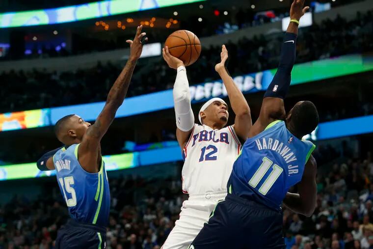 76ers forward Tobias Harris shoots as he is defended by Dallas Mavericks guards Delon Wright and Tim Hardaway Jr. during the first half.
