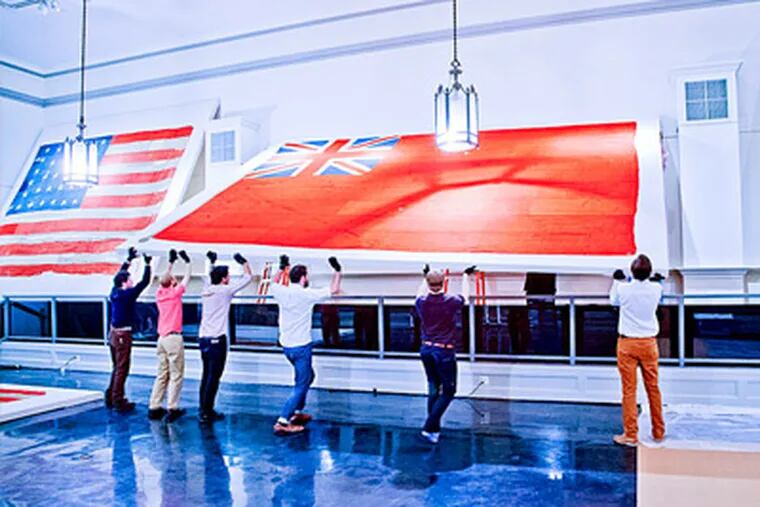 The rare English naval red ensign is hoisted into place at Freeman's. Estimate: $30,000 to $50,000. ELIZABETH FIELD/ Freeman's