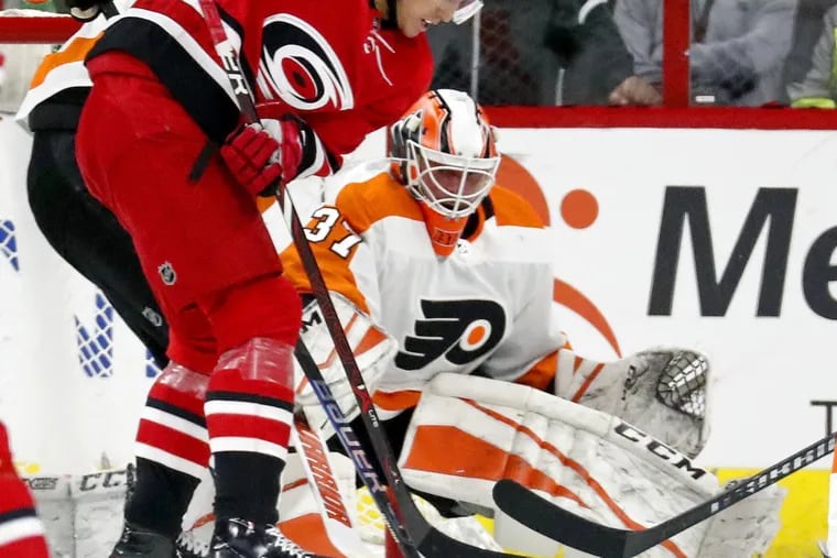 Victor Rask (49) tries to ram the puck past Brian Elliott during the second period of the Flyers win at Carolina on Tuesday. Elliott stole this win for Philadelphia. (