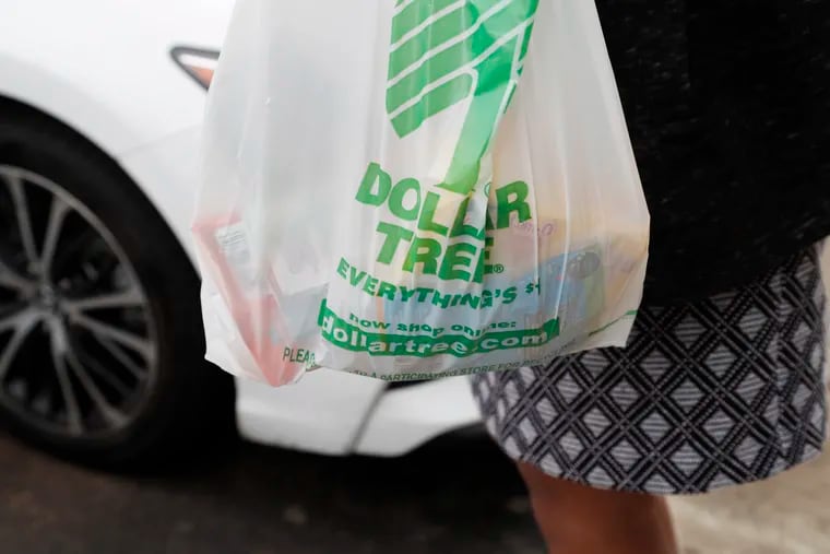 A customer carries a Dollar Tree shopping bag at a store in Richland, Miss.