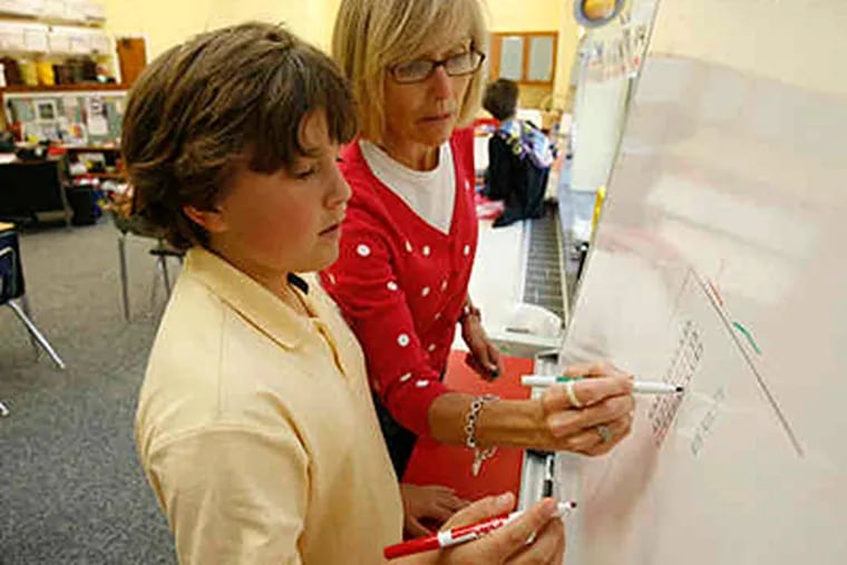 Stratford Friends School teacher Debbie Koutsiouroubas works with Jack Benoliel. While &quot;other programs jump to abstract quickly,&quot; she said, she tries to give students a picture of math basics. (Charles Fox / Staff)