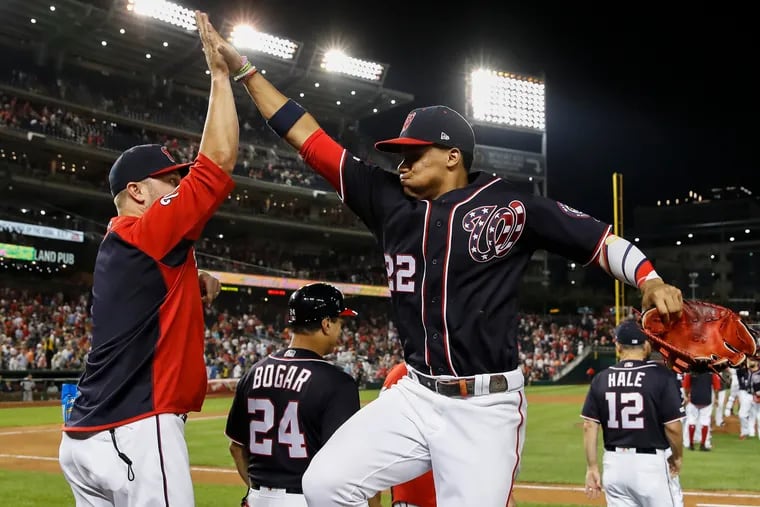 Washington Nationals assistant hitting coach Joe Dillon (left) high-fiving outfielder Juan Soto after an August victory.