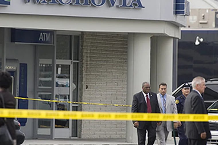 Police Commissioner Sylvester Johnson (left), flanked by chief of detectives Keith Sadler, leaves the Wachovia Bank where a fatal armored car holdup took place this morning.