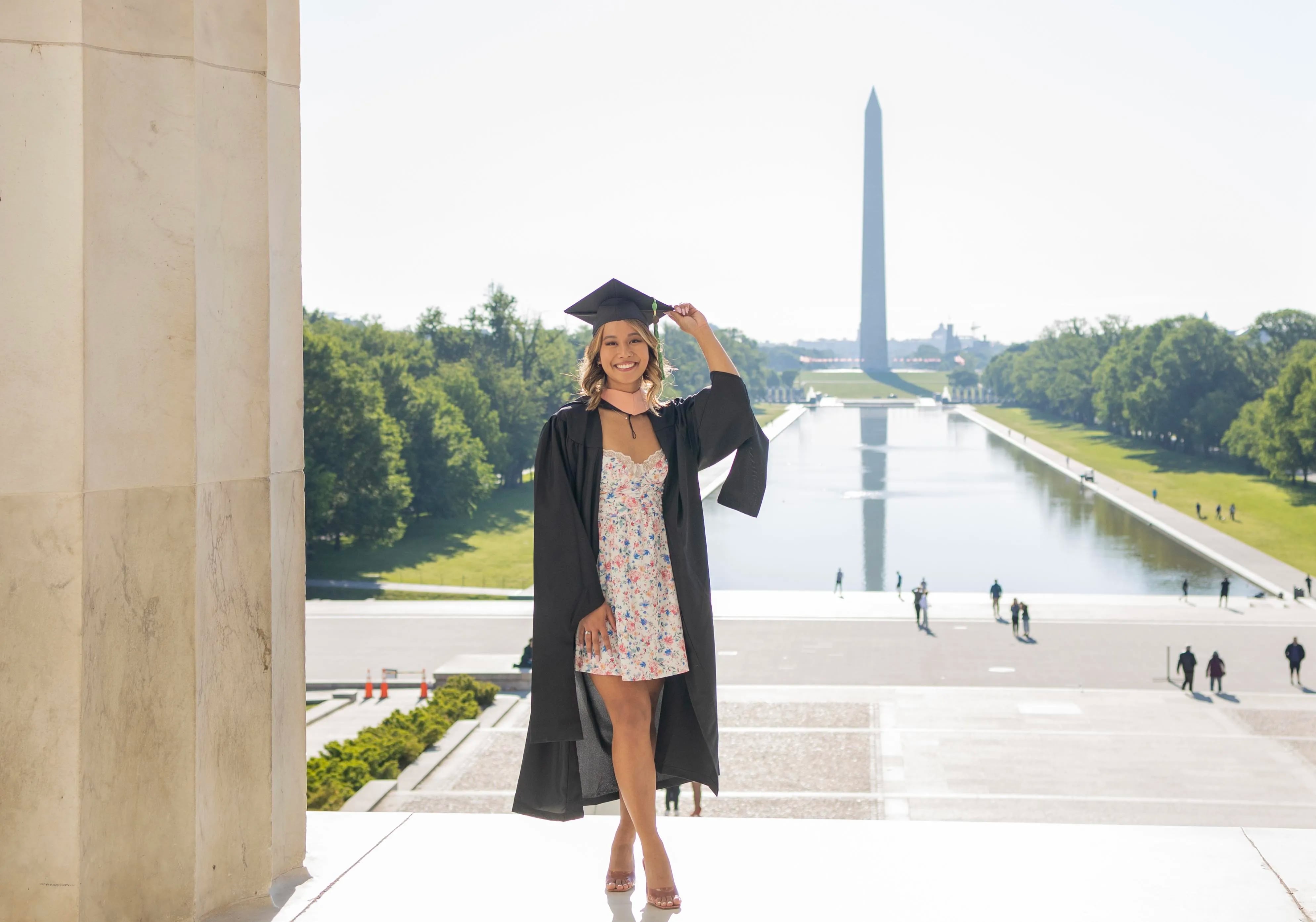 Muriel Movida poses for a photo on the National Mall in Washington after graduating with her master's degree in public health in 2022. She now has $33,000 in student loan debt from two degrees.