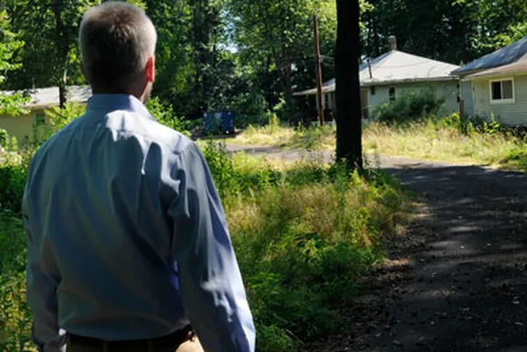 CORRECTING DATE PHOTO WAS MADE: Chris Auth (cq) walks toward the four small bungalows sitting empty in the woods off busy Bridgewater Road in Bensalem July 2, 2012.  ( TOM GRALISH / Staff Photographer )